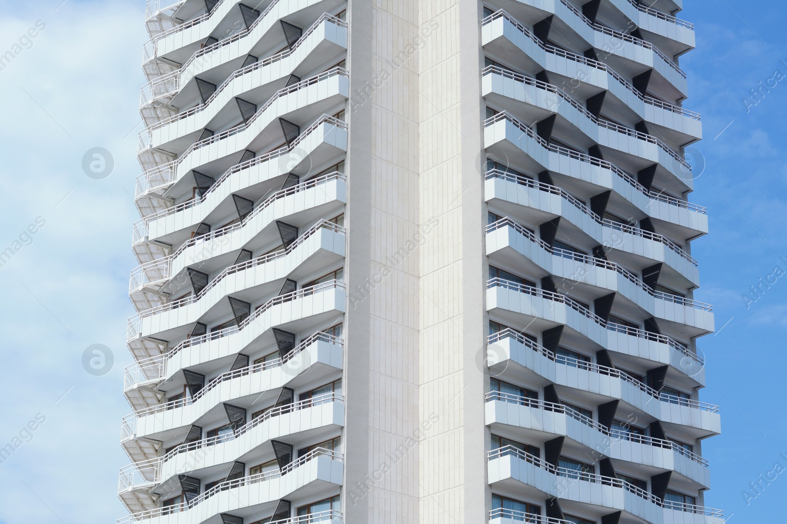 Photo of Exterior of beautiful building with balconies against blue sky, low angle view