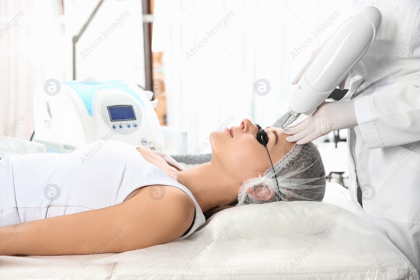 Photo of Young woman undergoing laser removal of permanent makeup in salon. Eyebrow correction