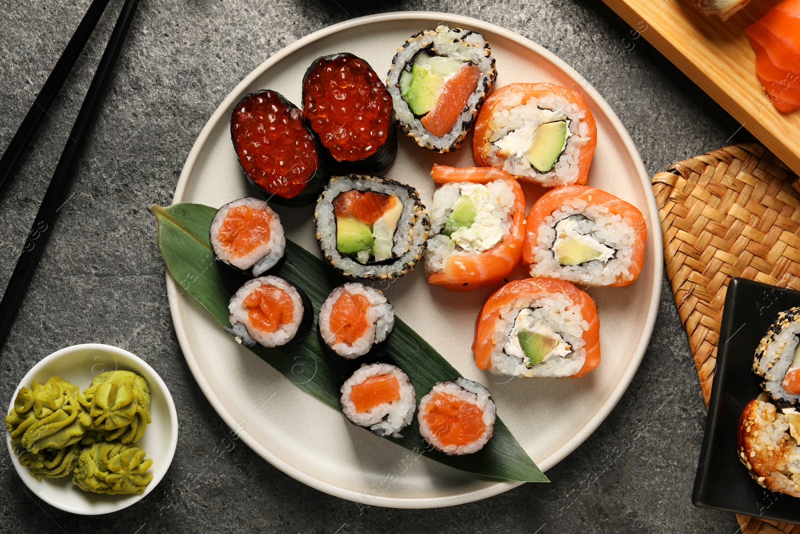 Photo of Flat lay composition with delicious sushi rolls on dark grey table