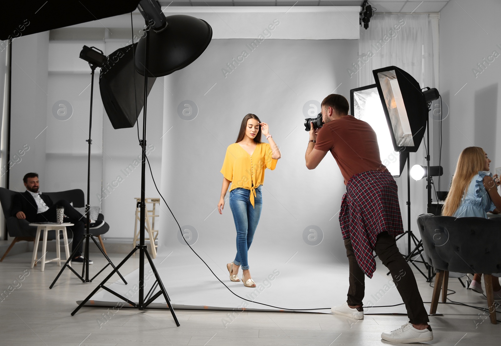 Photo of Professional team working with model in photo studio