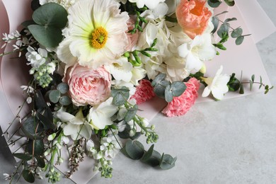 Photo of Bouquet of beautiful flowers on light grey table, above view