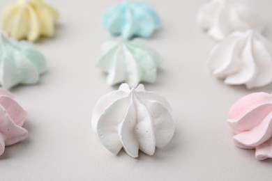 Delicious meringue cookies on light background, closeup