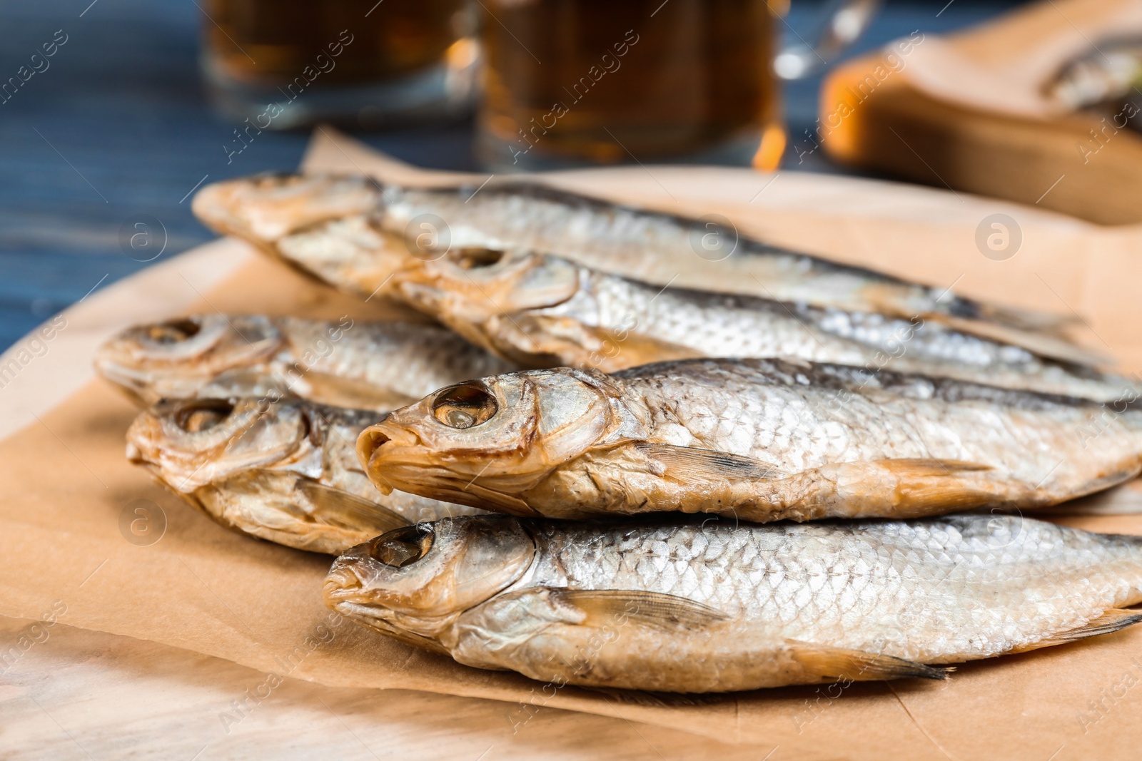 Photo of Tasty dried fish on wooden board, closeup