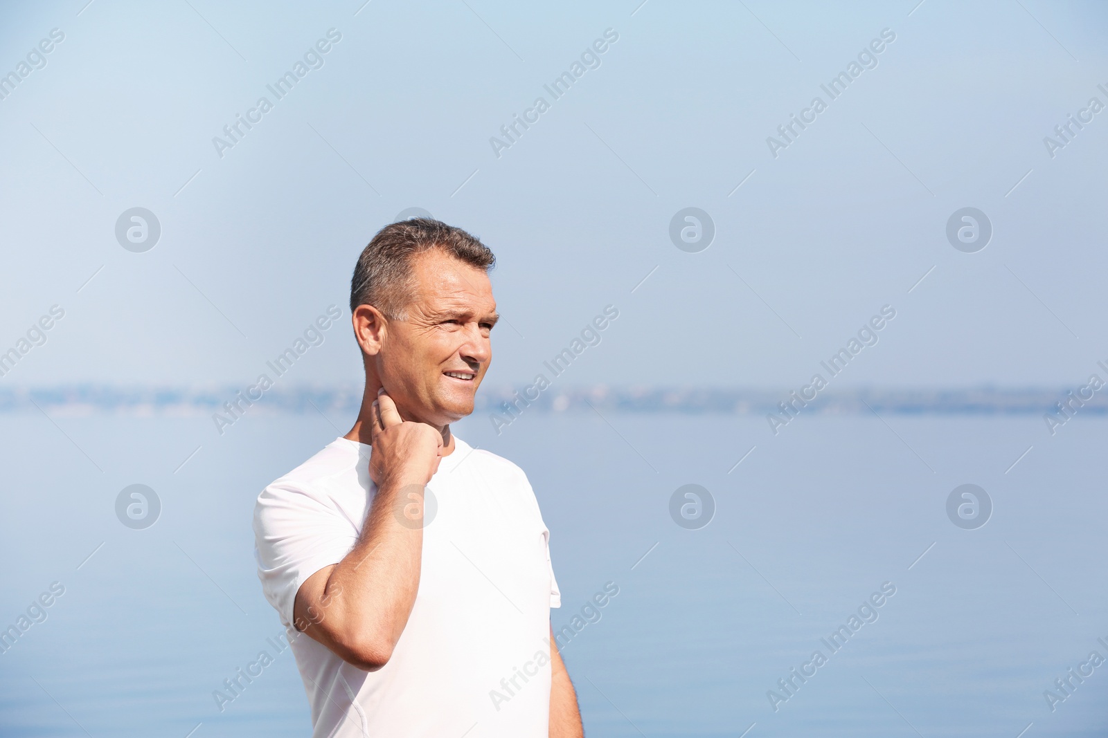 Photo of Man checking pulse outdoors on sunny day