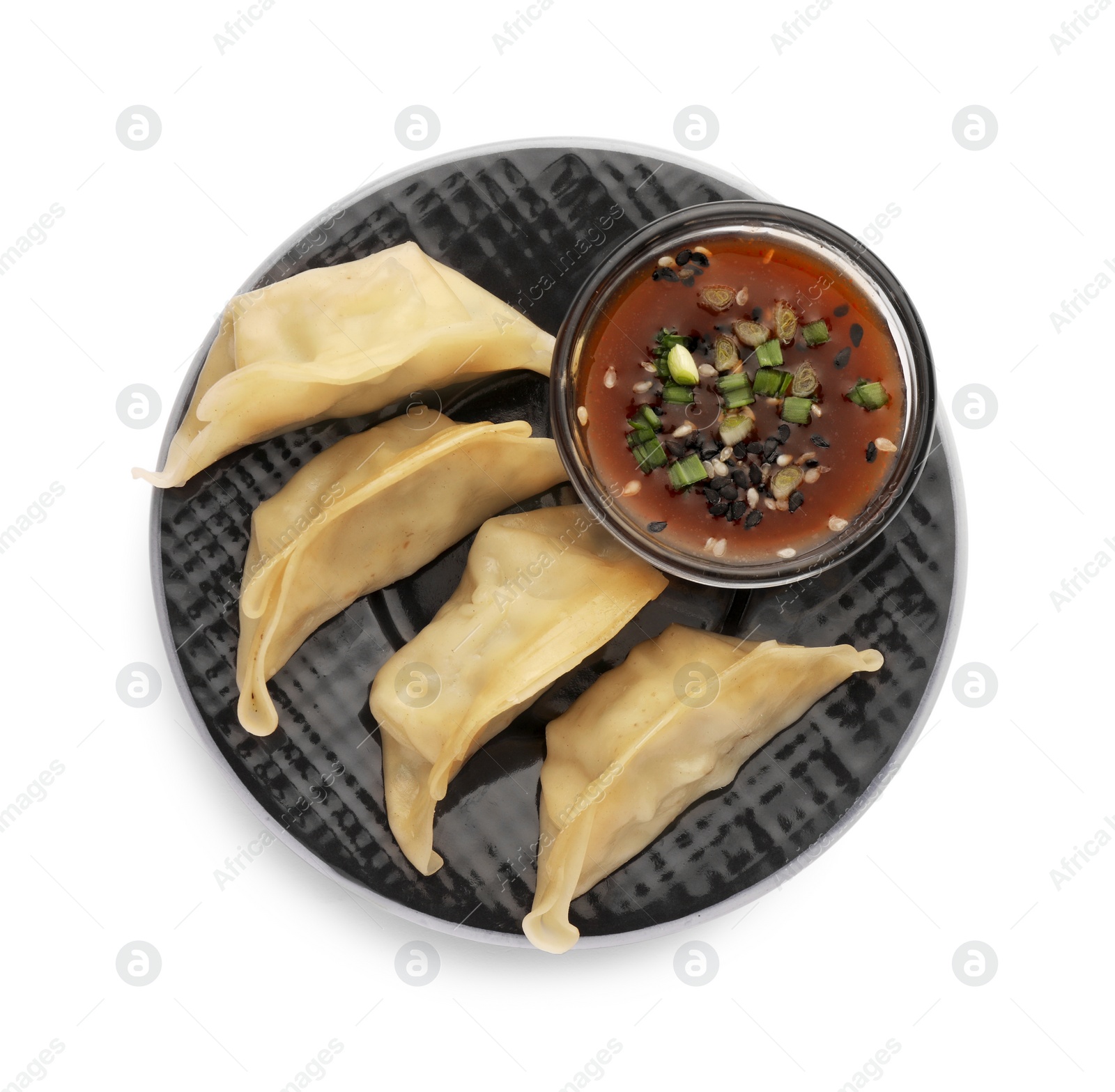 Photo of Delicious gyoza (asian dumplings) with sauce, onion and sesame isolated on white, top view