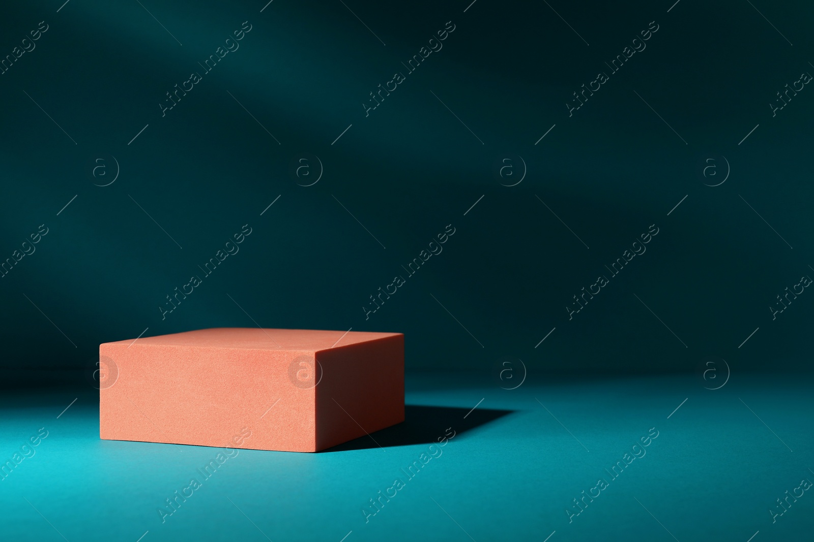 Photo of Orange stand on teal background, space for text. Stylish presentation for product