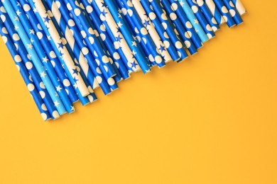Photo of Many paper drinking straws on yellow background, flat lay. Space for text