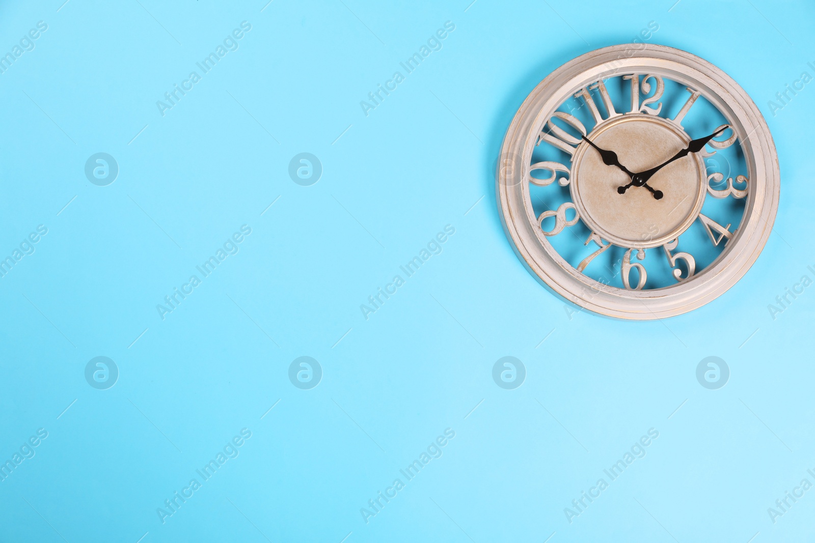 Photo of Stylish wall clock on turquoise background, top view. Space for text