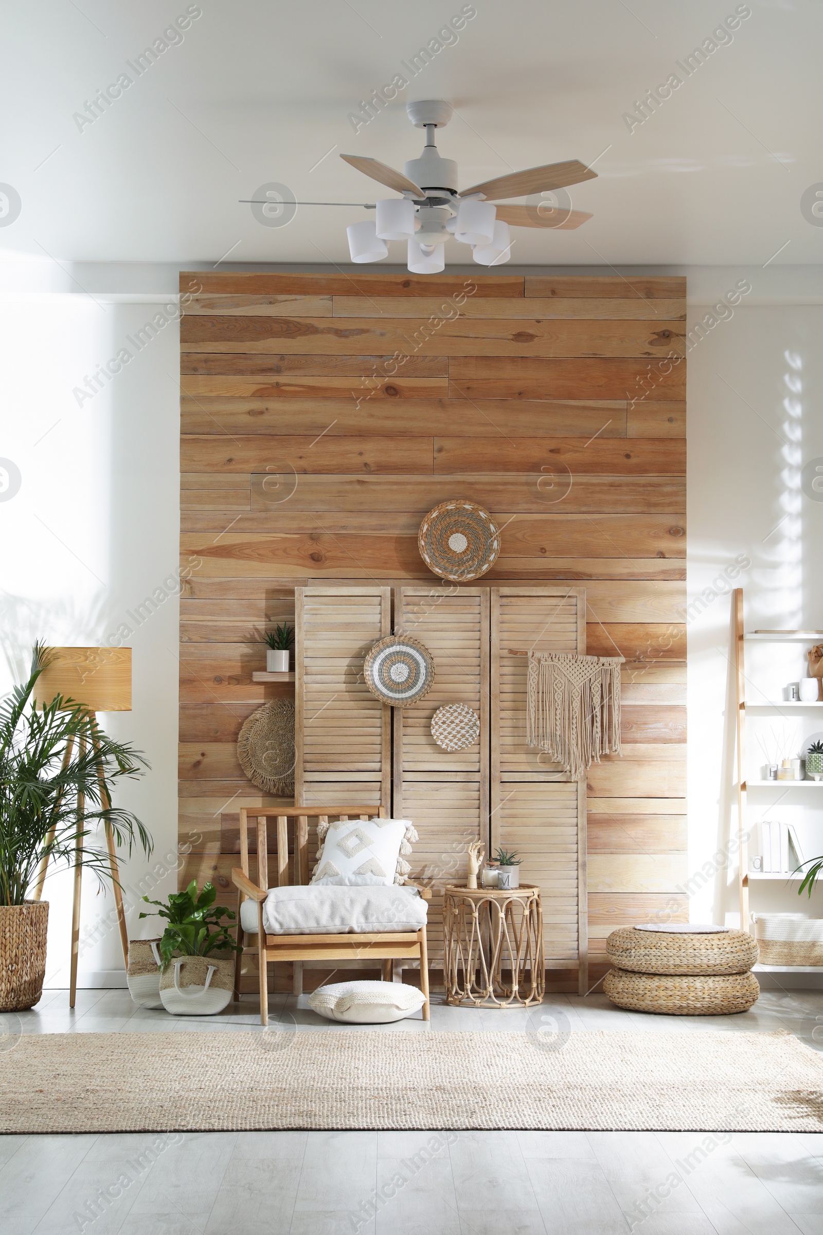 Photo of Stylish living room interior with comfortable wooden armchair and beautiful houseplants