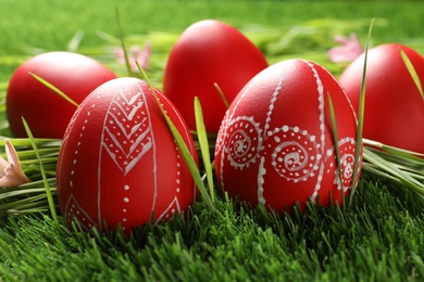 Photo of Red painted Easter eggs on green grass