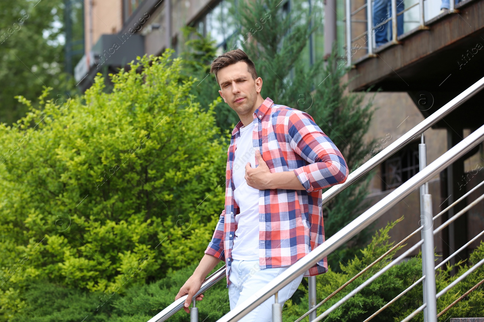 Photo of Young man having chest pain outdoors. Heart attack