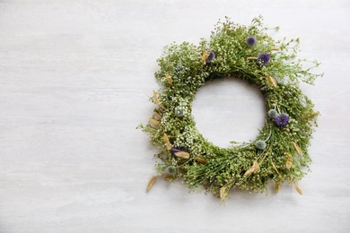 Photo of Beautiful wreath made of wildflowers on white table, top view. Space for text