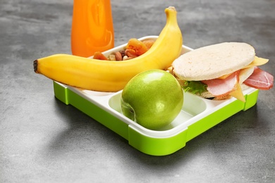 Lunch box with appetizing food on table