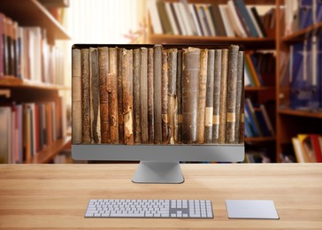 Image of Online library. Modern computer on wooden table and shelves with books indoors