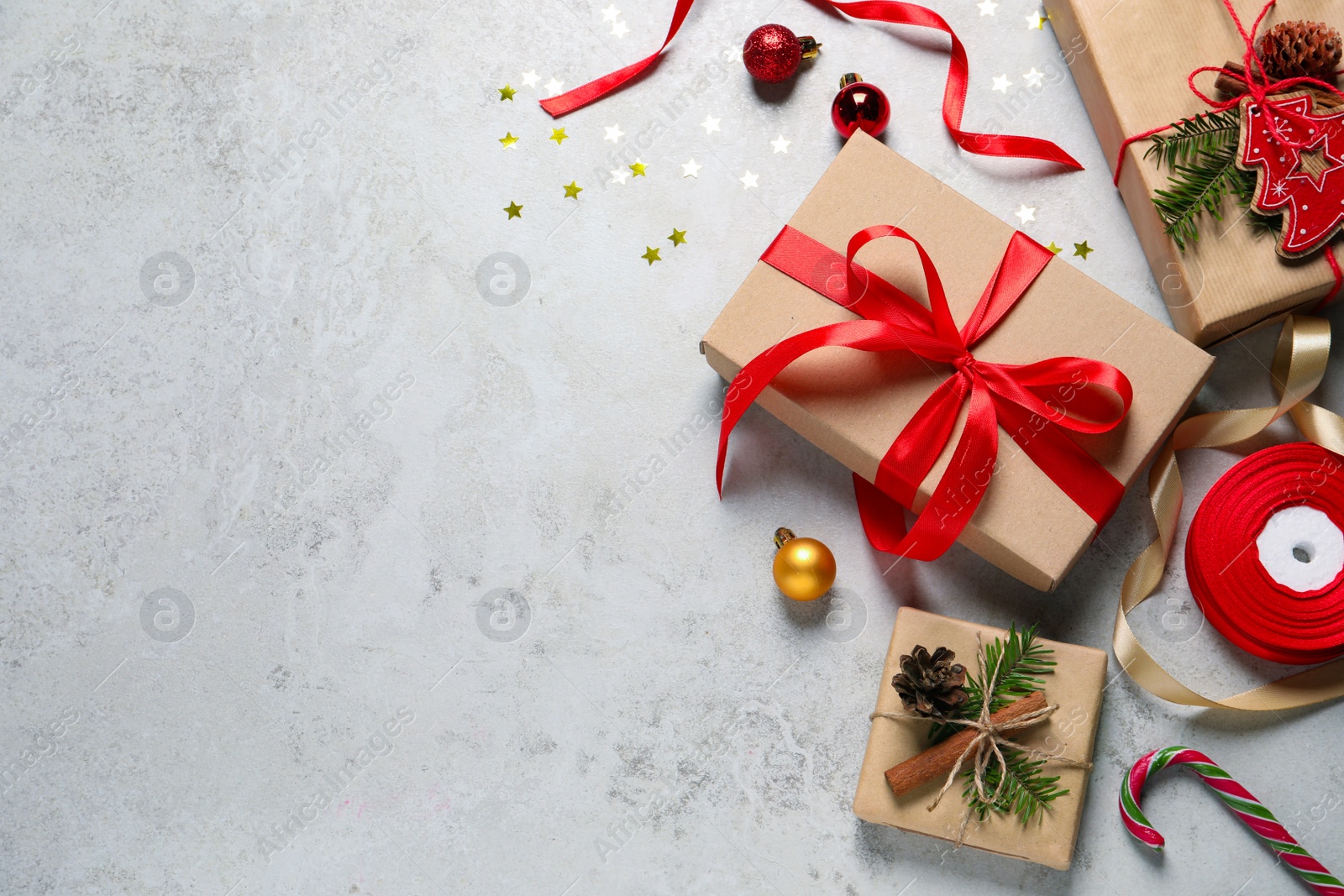 Photo of Flat lay composition with beautiful gift boxes and Christmas decorations on light grey table. Space for text