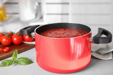 Delicious tomato sauce on light grey table