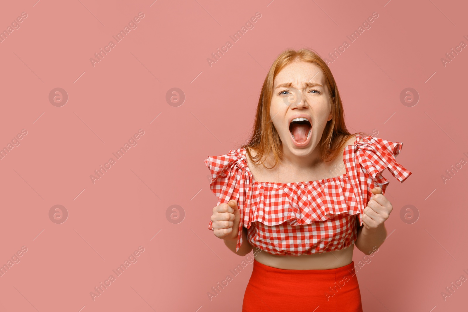 Photo of Portrait of angry screaming woman on pink background, space for text