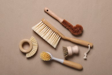 Photo of Cleaning brushes on pale brown background, flat lay