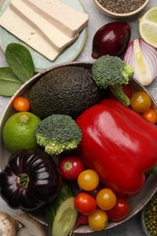 Photo of Different vegetables on grey table, flat lay. Vegan diet