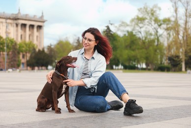 Photo of Woman with her cute German Shorthaired Pointer dog outdoors