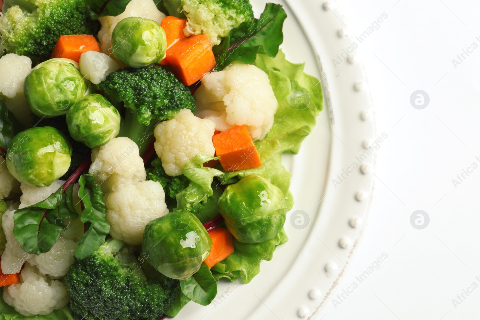 Photo of Plate of salad with Brussels sprouts and broccoli isolated on white, closeup