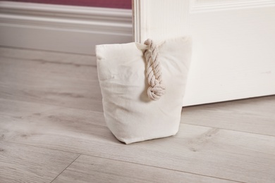 Photo of Stuffed bag holding wooden door at home