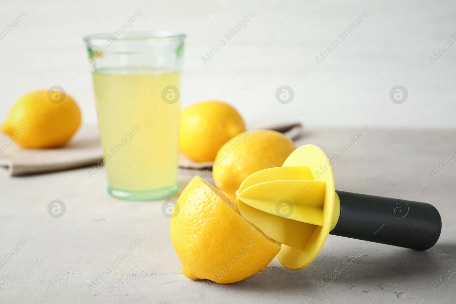 Photo of Fresh ripe lemon and reamer on table