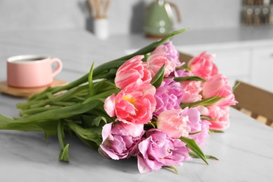Photo of Beautiful bouquet of colorful tulip flowers on white marble table indoors, closeup