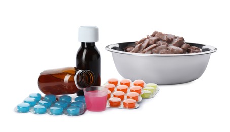 Image of Wet pet food in feeding bowl, syrup and vitamin pills on white background