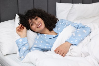 Photo of Beautiful young woman in stylish pyjama in bed at home