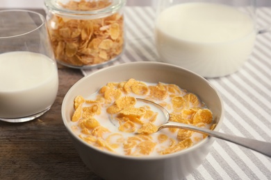 Healthy cornflakes with milk in bowl served on table