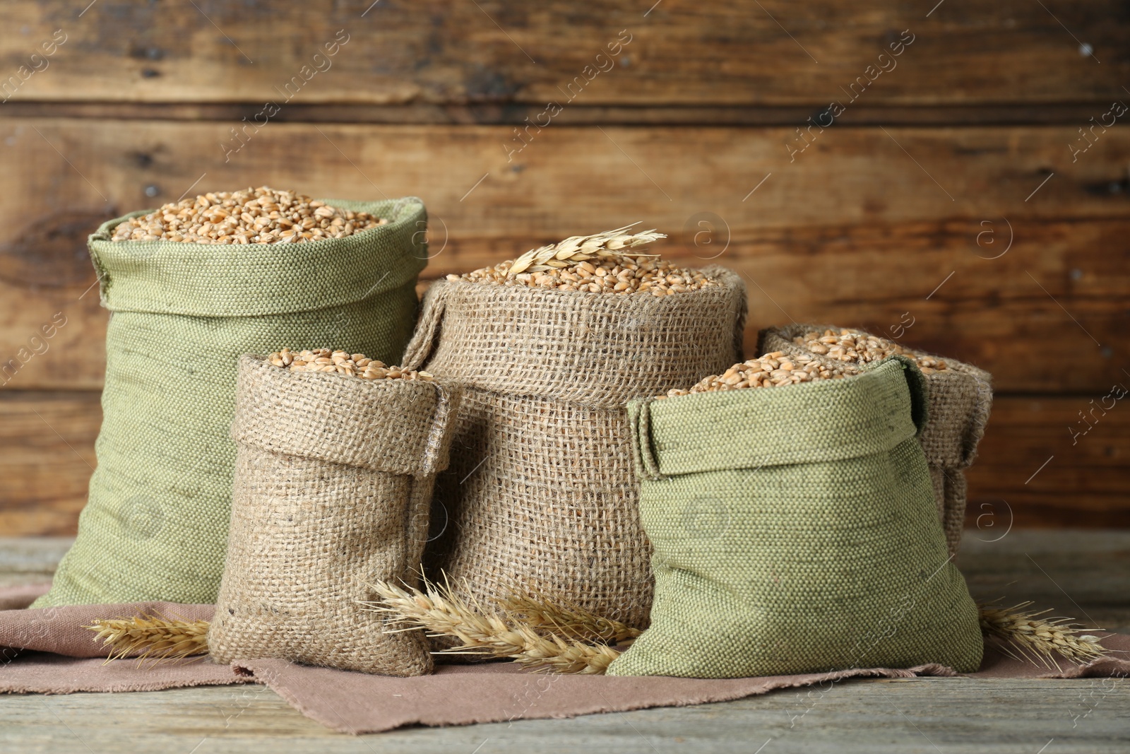 Photo of Many sacks with wheat grains wooden wall