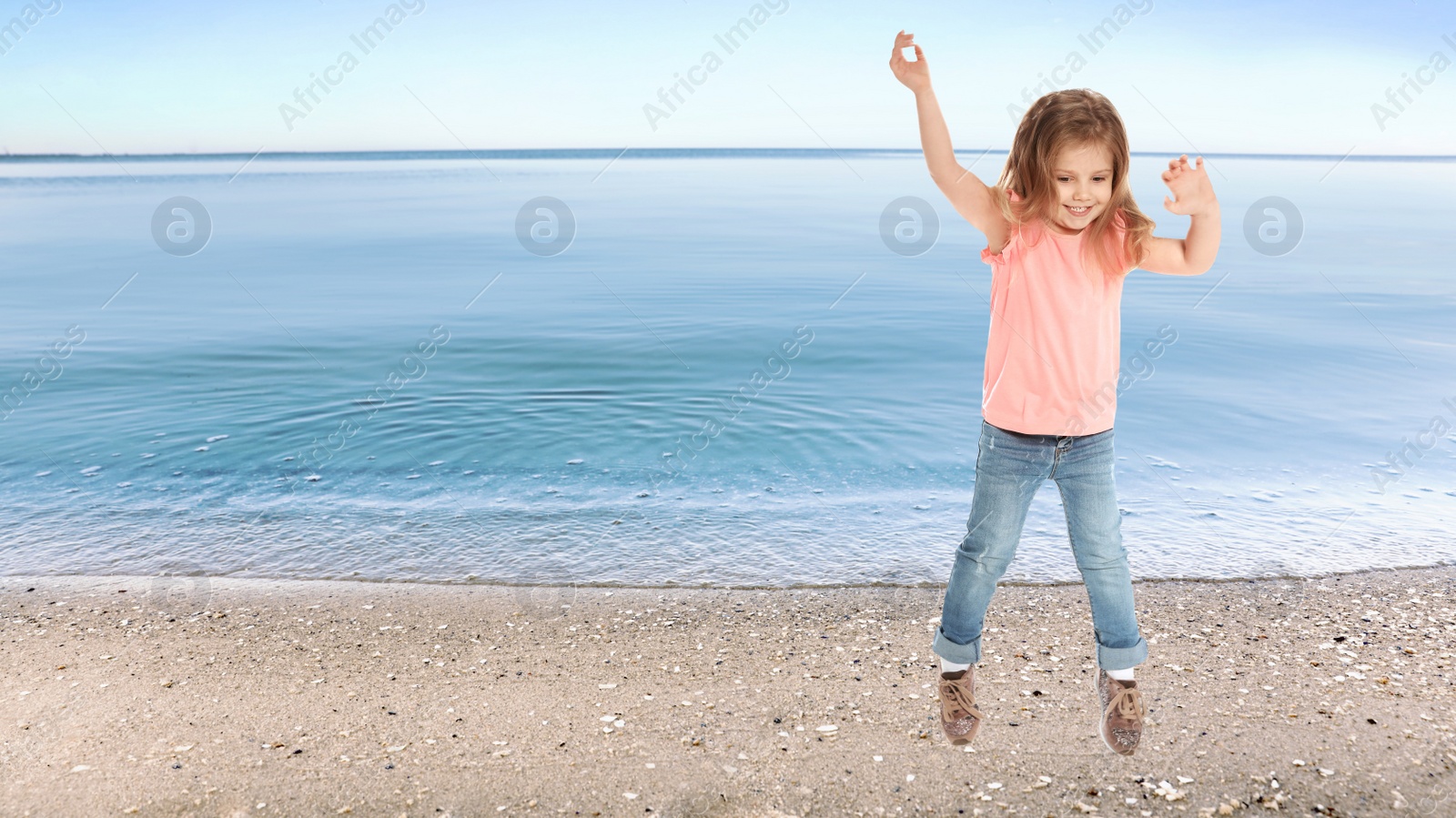 Image of Happy school girl jumping on beach near sea, space for text. Summer holidays