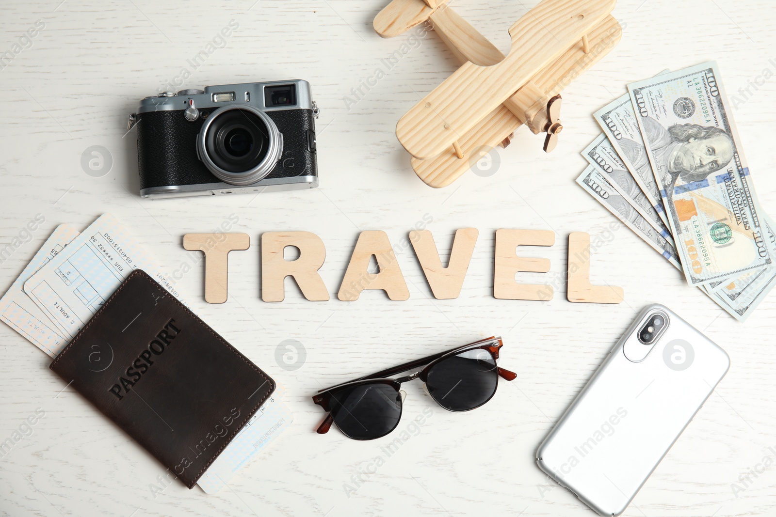 Photo of Flat lay composition with word TRAVEL, camera and passport on wooden background. Tourist agency