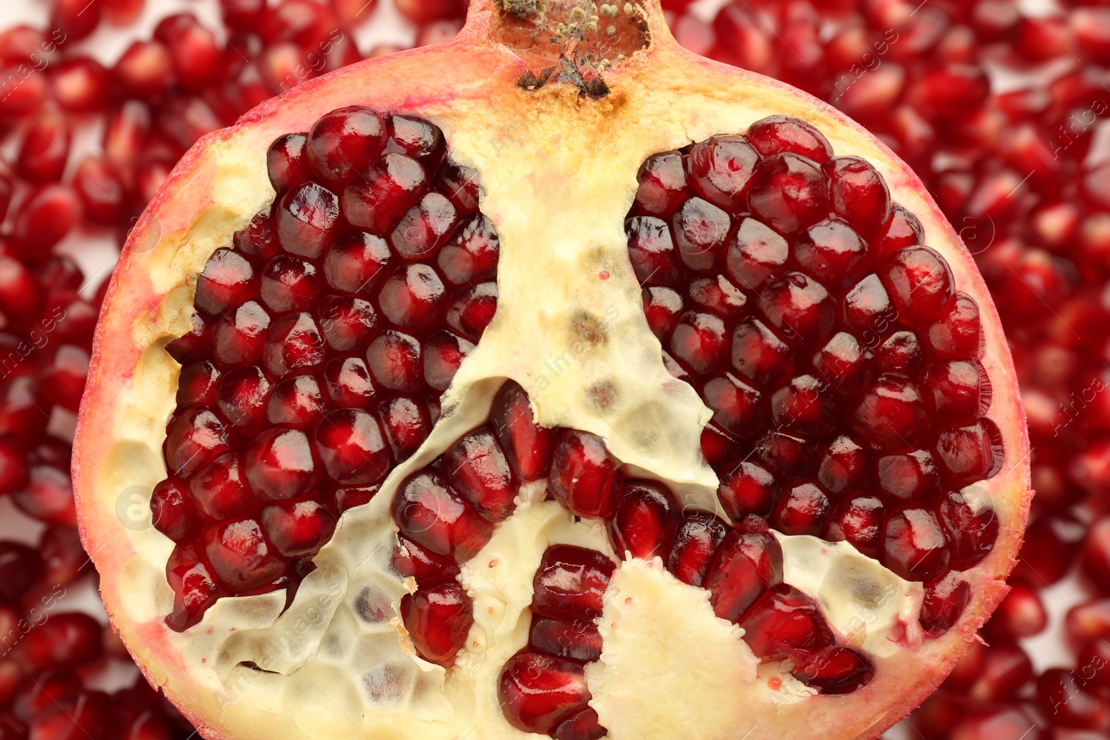 Photo of Ripe juicy red pomegranate on grains grains, top view