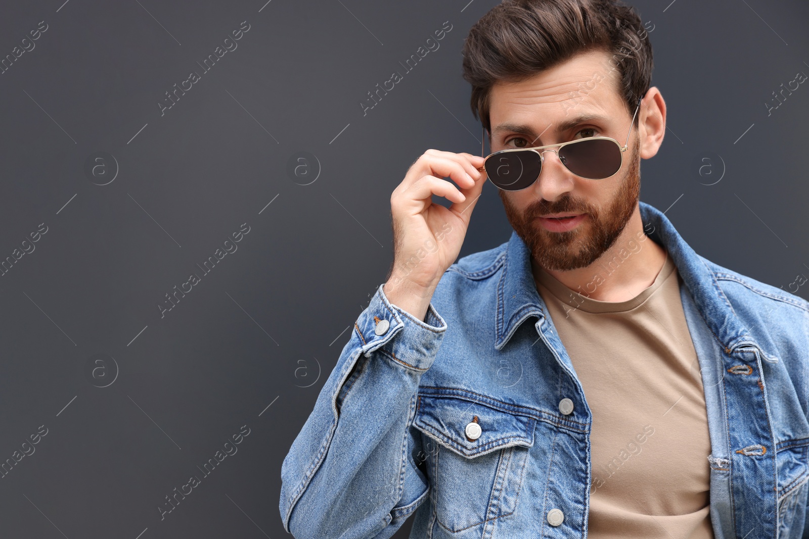 Photo of Portrait of handsome bearded man with sunglasses on grey background. Space for text
