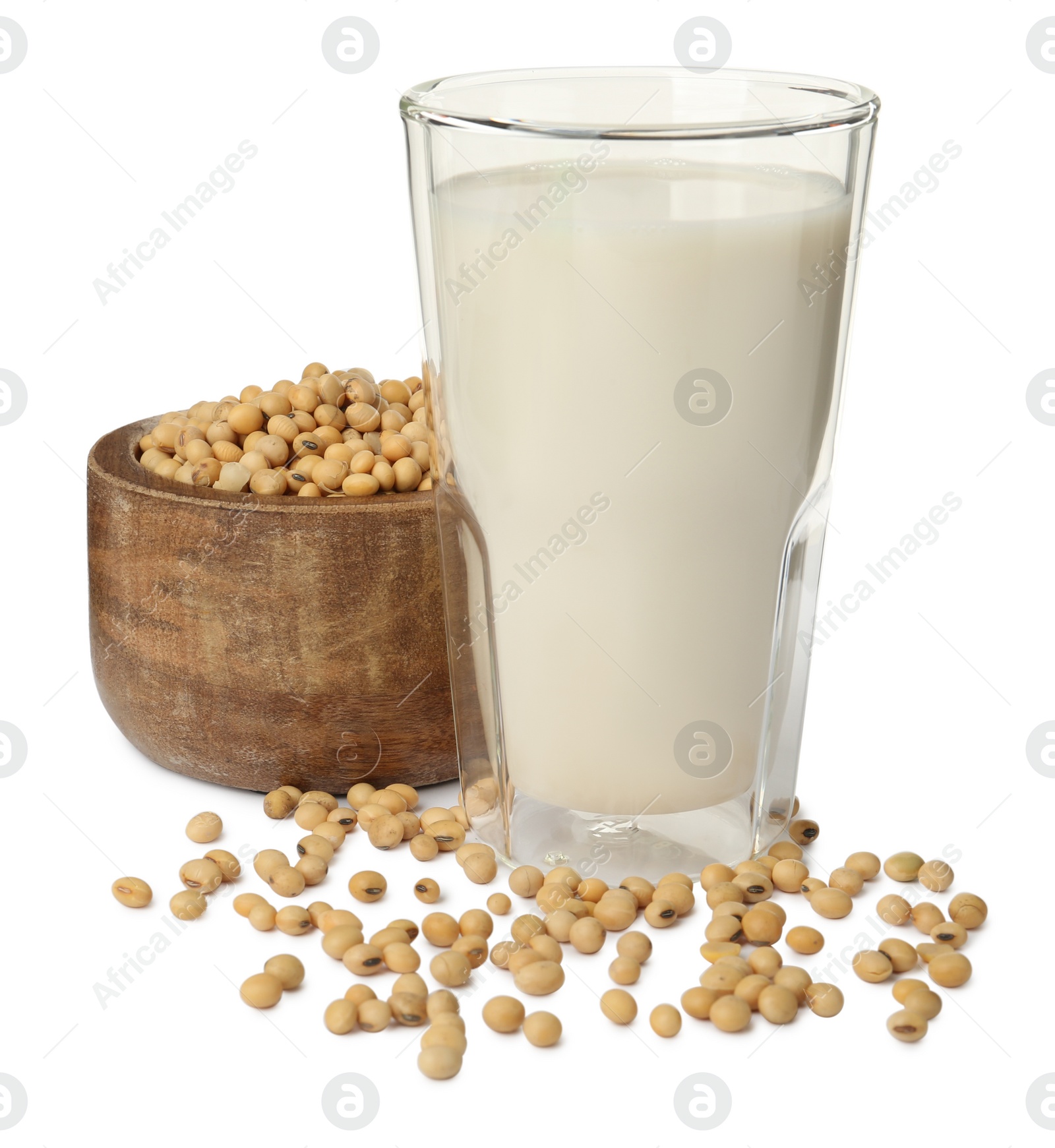 Photo of Glass of fresh soy milk and bowl with beans on white background