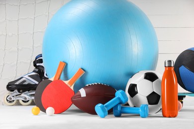 Photo of Many different sports equipment on white table
