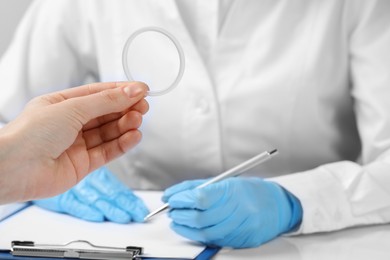 Woman holding diaphragm vaginal contraceptive ring at the doctor's appointment, closeup
