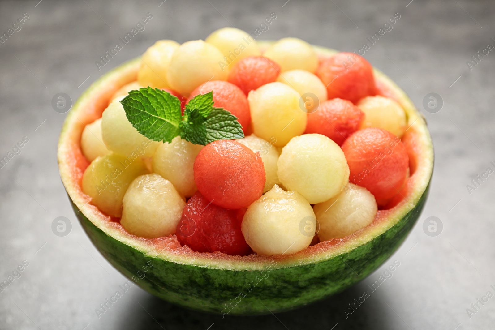 Photo of Melon and watermelon balls with mint served on grey table