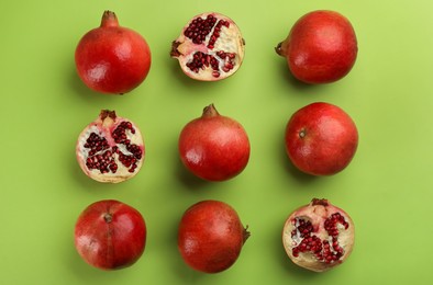 Flat lay composition with ripe pomegranates on green background