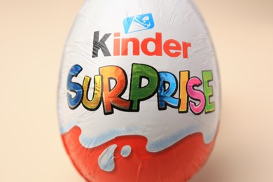 Photo of Slynchev Bryag, Bulgaria - May 25, 2023: Kinder Surprise Egg on beige background, closeup