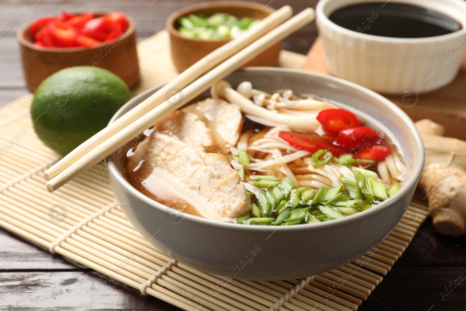 Photo of Delicious ramen with meat and ingredients on wooden table, closeup. Noodle soup