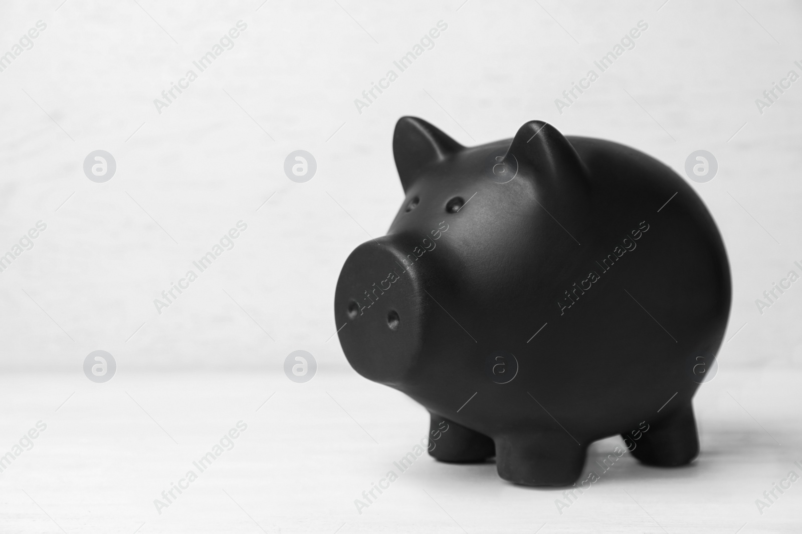 Photo of Black piggy bank on white table. Money saving