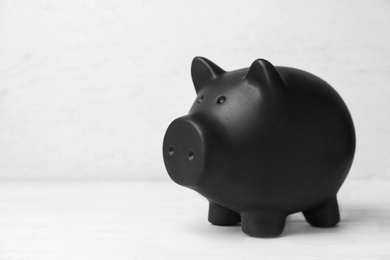 Photo of Black piggy bank on white table. Money saving