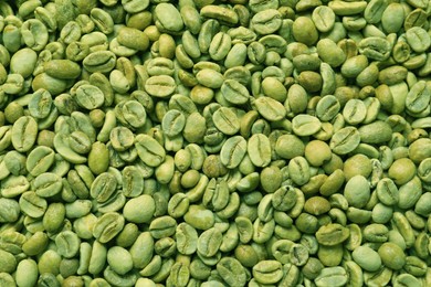 Many green coffee beans as background, top view