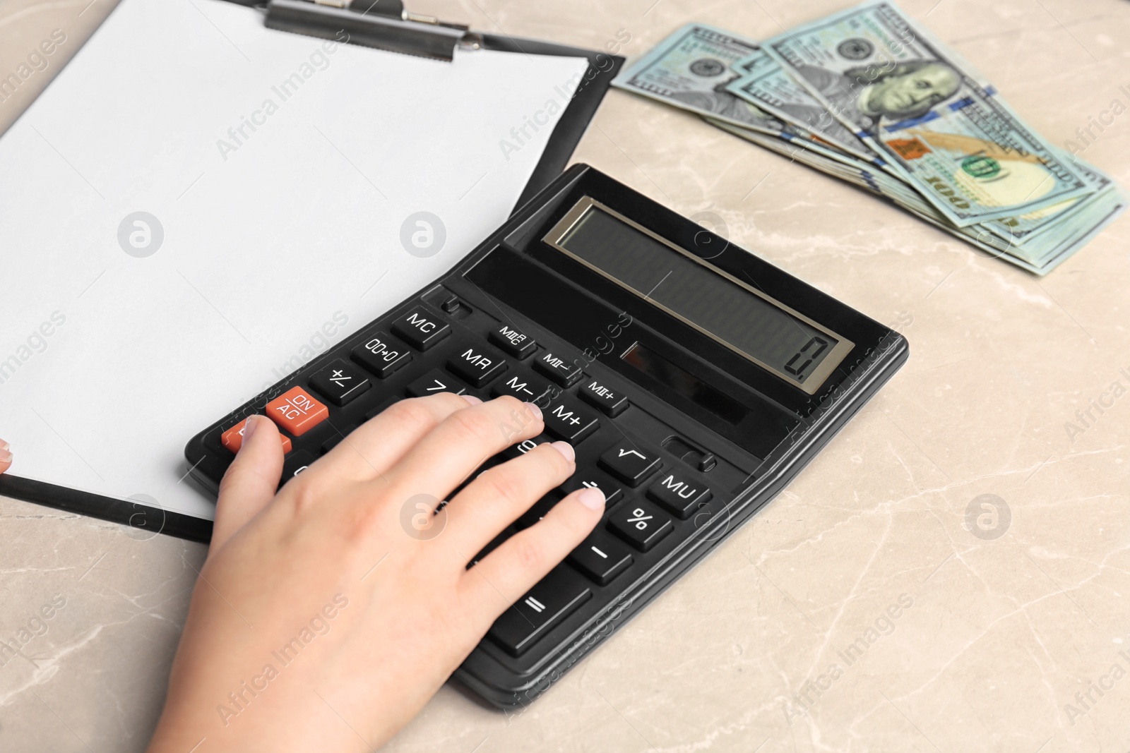 Photo of Woman using calculator at table, closeup. Tax law concept