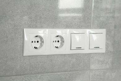 Photo of Light switches and power sockets on wall indoors
