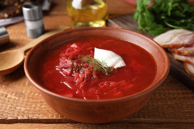 Photo of Clay bowl with Ukrainian borsch served on wooden table