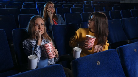 Photo of Rude woman talking on phone and disturbing other viewers in cinema